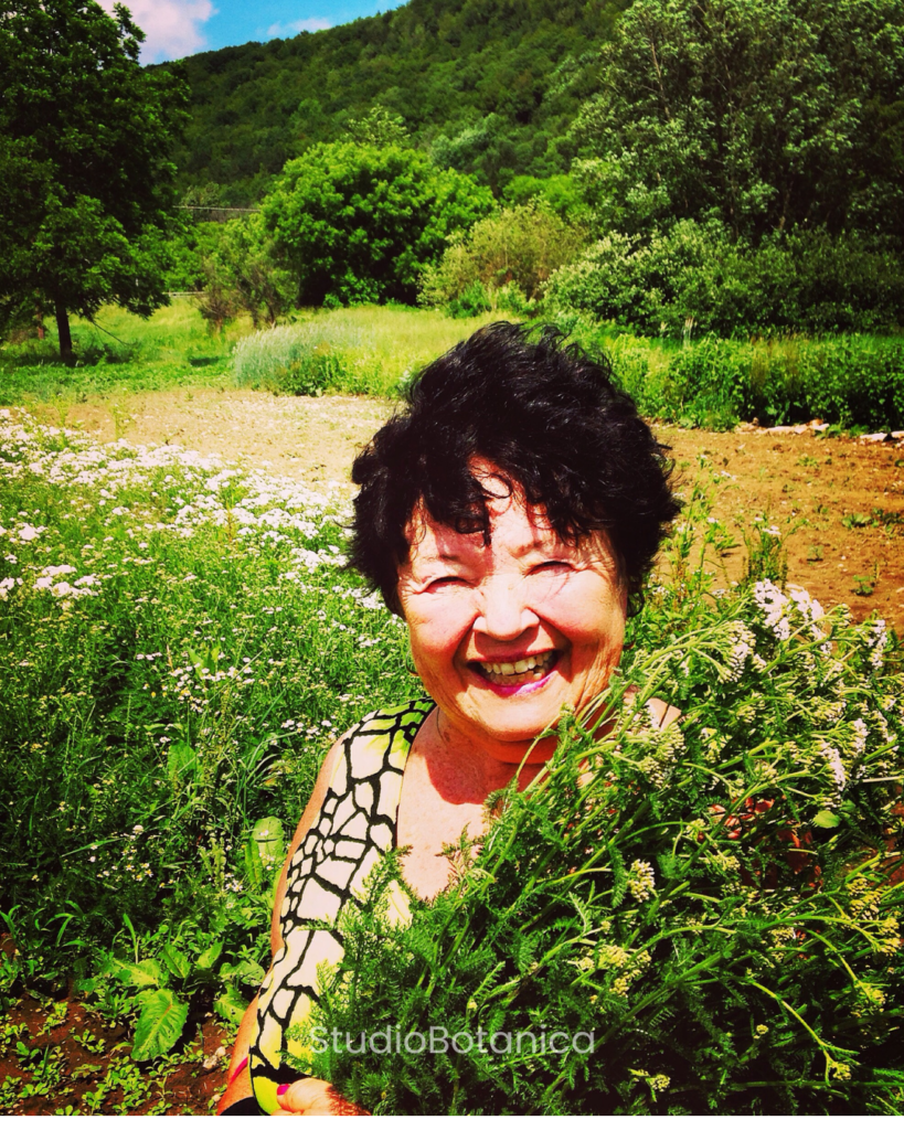Carol with flowers standing in rural landscape